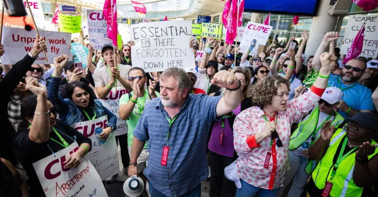 CUPE President Mark Hancock with his fist raised in solidarity with many airline workers at an airport