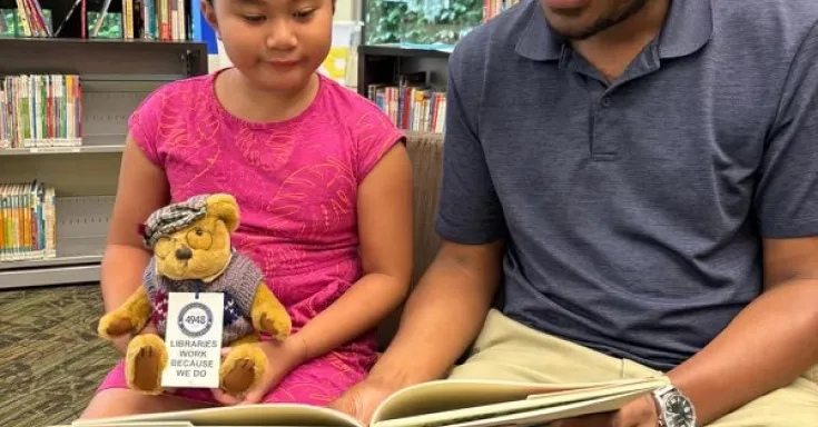 Person reading with a child in a library