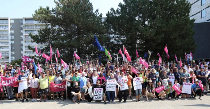 Crowd of people posing for a photo with signs and flags 