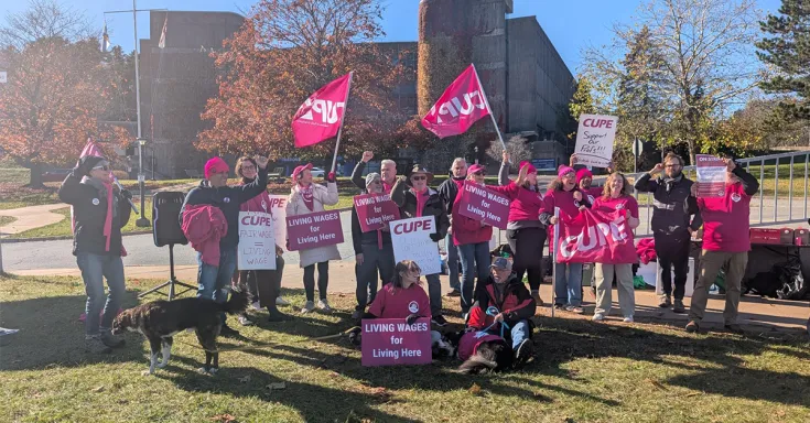 People on a picket line with signs and flags