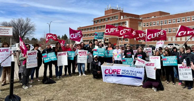 People in front of a building with signs and flags 