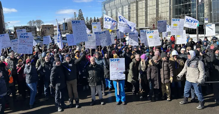 Group of people with picket signs and flags