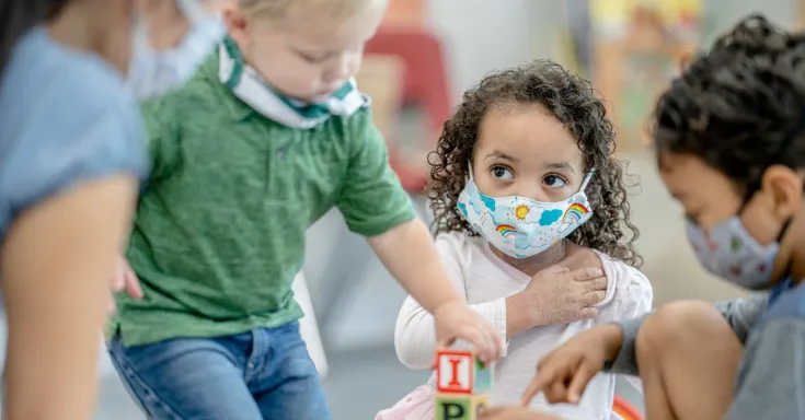 Children playing wearing masks