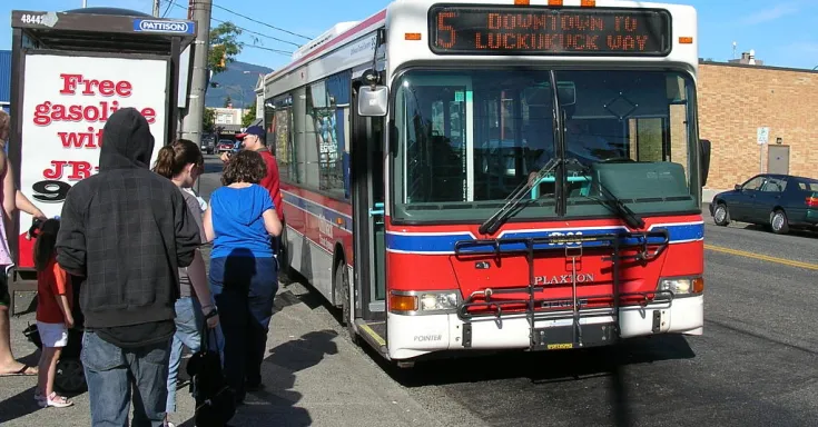 Public transit bus at a bus stop with passengers boarding