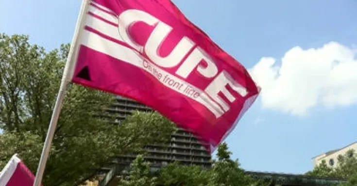 Pink CUPE flag against a blue sky