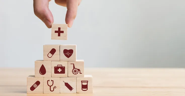 Hand arranging wood block stacking with healthcare icons