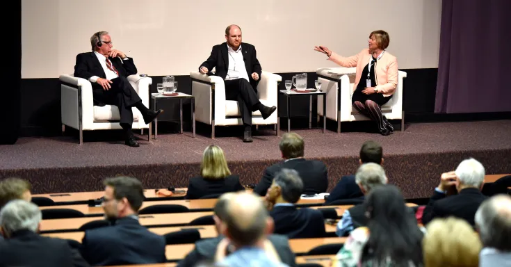 Mayor Billy Joe MacLean, city councilor Craig Sauvé and Charley Beresford on stage in front of large audience