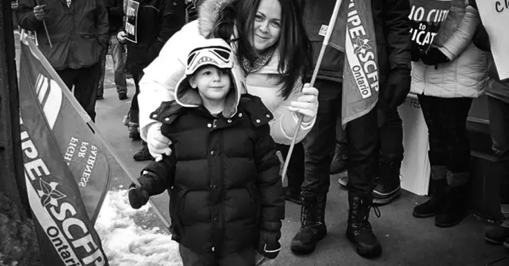 CUPE member and young child rally for education