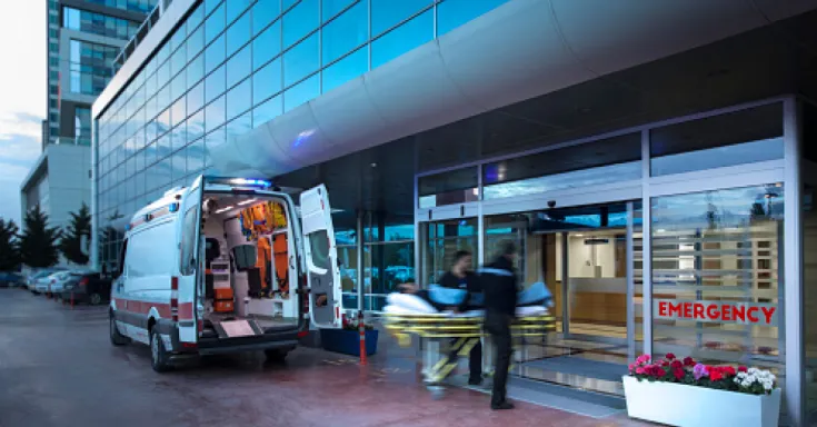 Paramedics taking patient on stretcher from ambulance to hospital