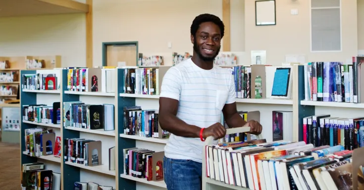 Library worker pushing a cart