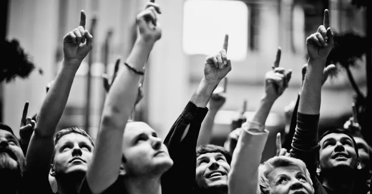 Large group of people pointing and looking up