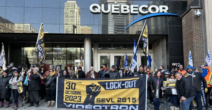 People posing for a photo with flags and signs